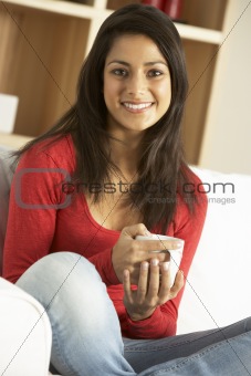 Woman sitting at home drinking coffee