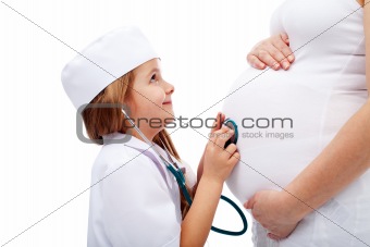 Expecting mother tummy examined by little girl