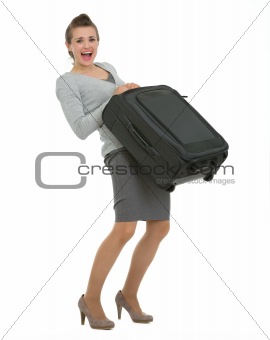 Tired traveling woman raising suitcase