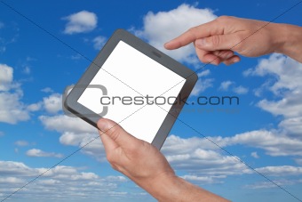 Tablet in hand against the sky.