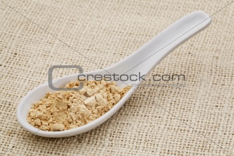 maca root powder on a ceramic spoon