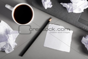 business creativity concept. Laptop, sheets of paper and crumpled wads on table.