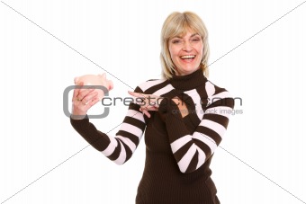 Happy elderly woman pointing on piggy bank