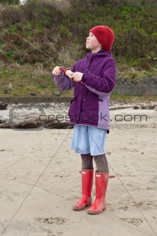 young girl flying kit on beach