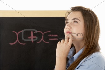 Thoughtful Looking Female Student Standing Next To Blackboard