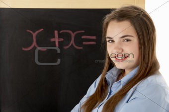 Female Student Standing Next To Blackboard