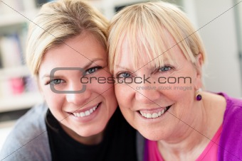 mother and daughter hugging, looking at camera
