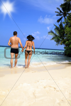 Loving couple walking on a tropical beach