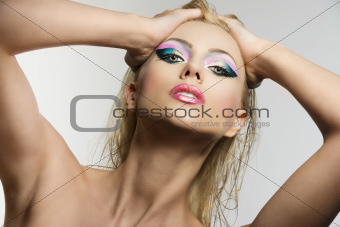 blonde girl's beauty portrait with both hands on her head