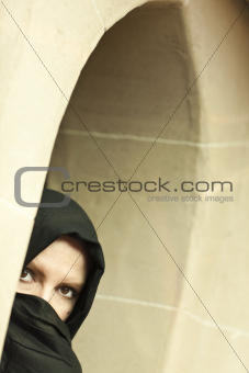 Cautious Islamic Woman in a Window Pane Wearing Traditional Burqa or Niqab.