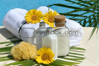Spa products and towels by the pool
