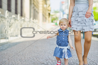 Baby with mother walking in city