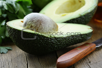 avocado cut in half on a wooden table