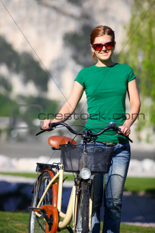 Portrait of a young Caucasian woman with her bike