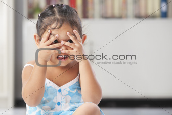 Little girl playing peekaboo
