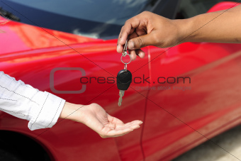 woman receiving car key from salesman