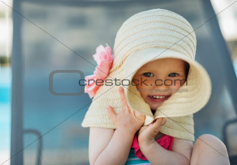 Portrait of baby hiding in big hat