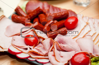 platter of cold cuts and sausages with ham and tomatoes