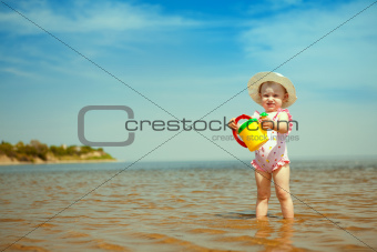 child with watering-pot on the seashore