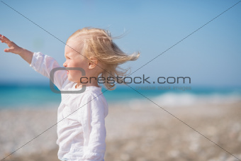 Baby on beach looking into distance