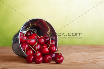 Cherries in a bucket on old wooden table