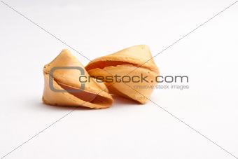 Two unbroken fortune cookies touching against faded white background