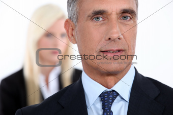 Male executive with female colleague out of focus in the background