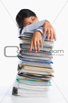 Woman tired behind pile of paper