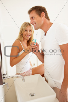 Young Couple Brushing Teeth In Bathroom