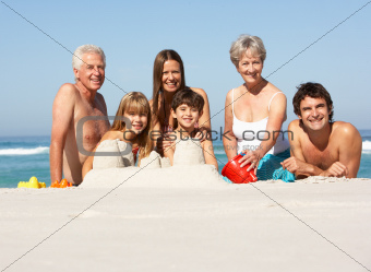 Three Generation Family Building Sandcastles On Beach Holiday