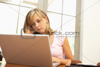Worried Looking Teenage Girl Using Laptop At Home
