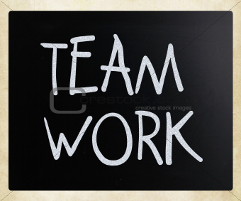 "Teamwork" handwritten with white chalk on a blackboard