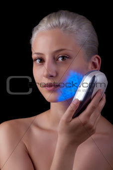 Young woman getting photo-therapy treatment with blue light 