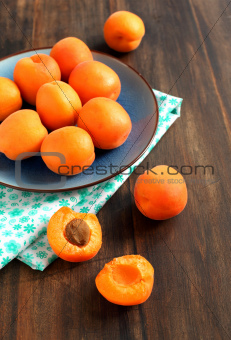 Bowl of fresh apricots on a wooden table
