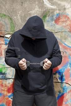 Man in handcuffs on a wall background