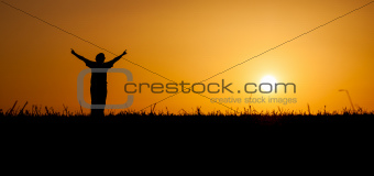 Person celebrating life at sunset