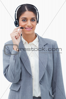 Smiling call center agent adjusting microphone