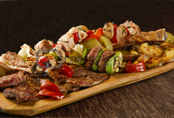Rustic tray with various meats, mushrooms and assorted vegetables - isolated