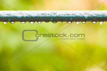 Raindrops on a fence in city park or garden