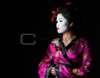 Portrait of geisha looking on copy space isolated on black