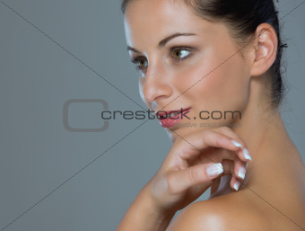 Beauty portrait of girl showing well-groomed hands on gray