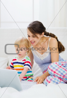 Modern young mother and baby using laptop