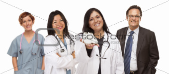 Attractive Hispanic Female Doctor or Nurse Holding Out Baby Shoes and Support Staff Behind Isolated on a White Background.