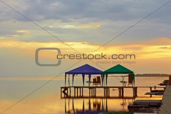 Tents above sea water at sunset