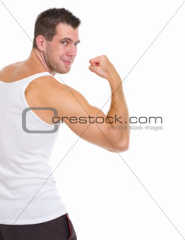 Happy male athlete showing biceps