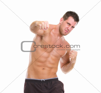 Angry muscular sports man punching
