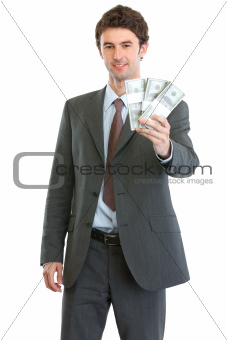 Smiling businessman showing packs of dollars