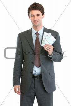 Smiling businessman showing packs of euros