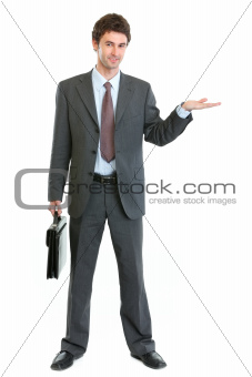Businessman with briefcase presenting something on empty hand
