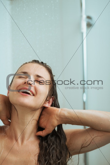 Happy woman bathing in shower under water jet